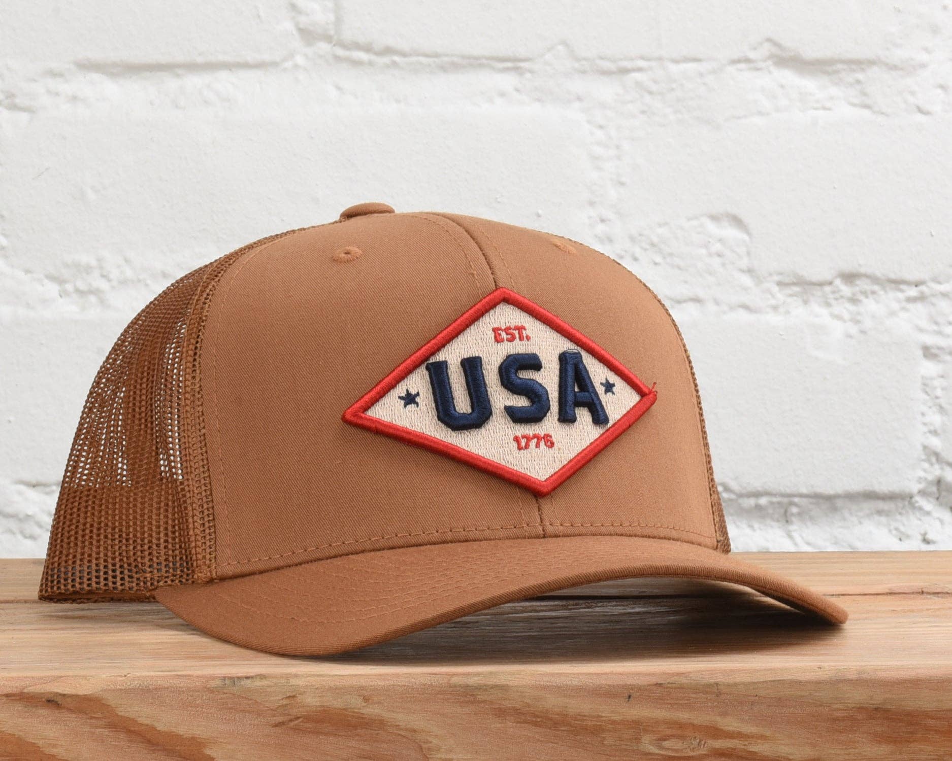 USA Est. 1776 embroidered patch trucker hat in Camo/Black, front view